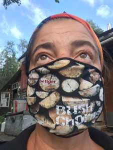 Portrait of Andrea Bettger wearing a mask featuring a print of her Bush Chords album cover.